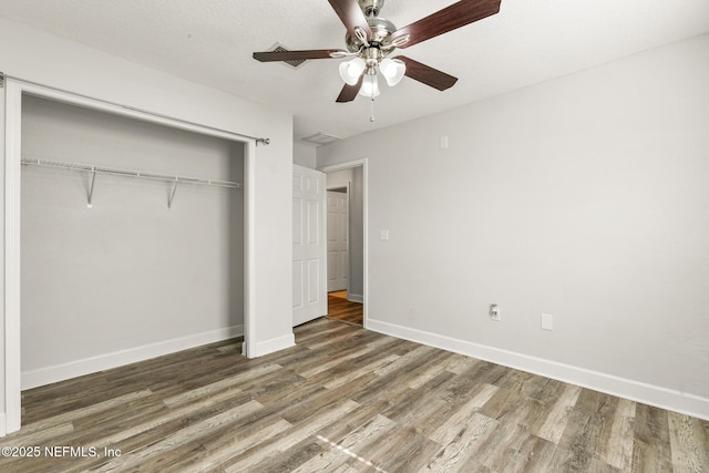 unfurnished bedroom with dark hardwood / wood-style floors, a closet, and ceiling fan