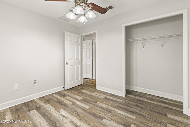 unfurnished bedroom featuring dark wood-type flooring, ceiling fan, and a closet