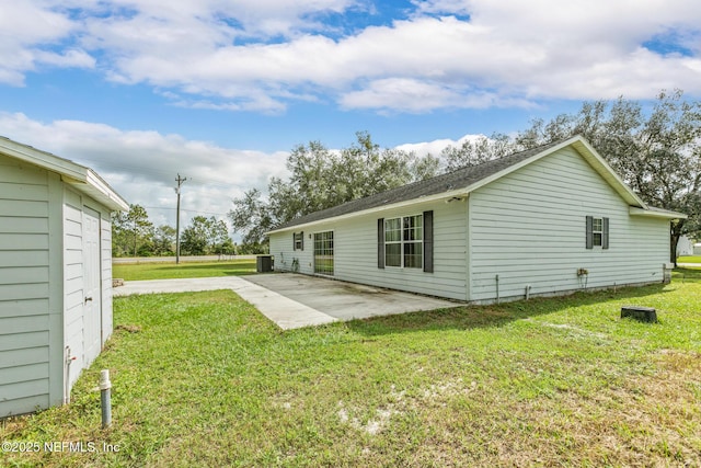 back of property featuring cooling unit, a patio area, and a lawn