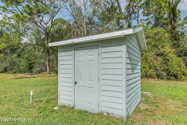 view of outbuilding with a yard