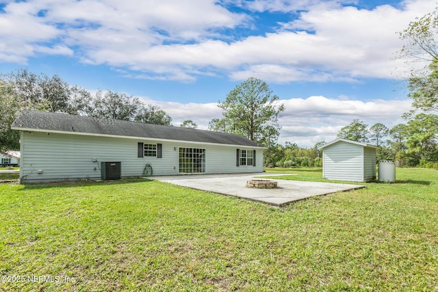 rear view of house with a fire pit, a shed, a yard, a patio area, and central air condition unit