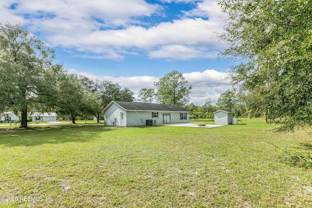 view of yard with a storage shed and a patio