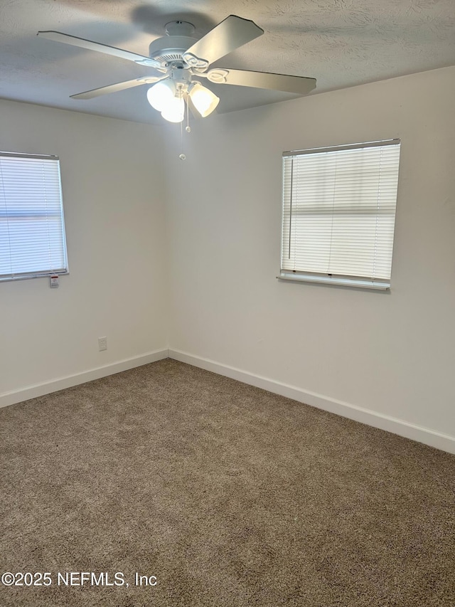 carpeted spare room with ceiling fan and a textured ceiling