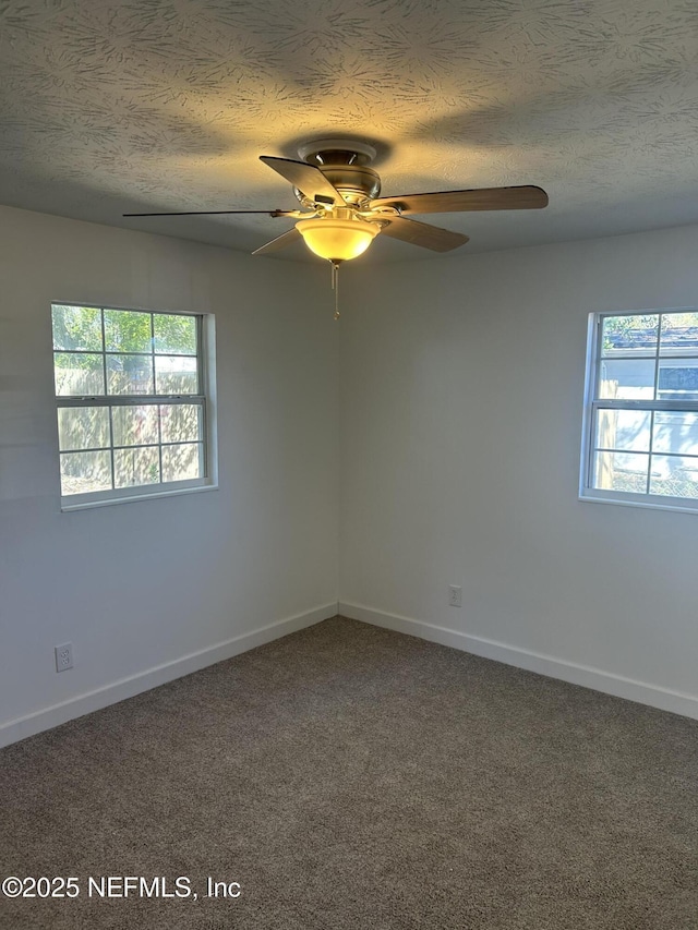 carpeted spare room featuring ceiling fan and a textured ceiling