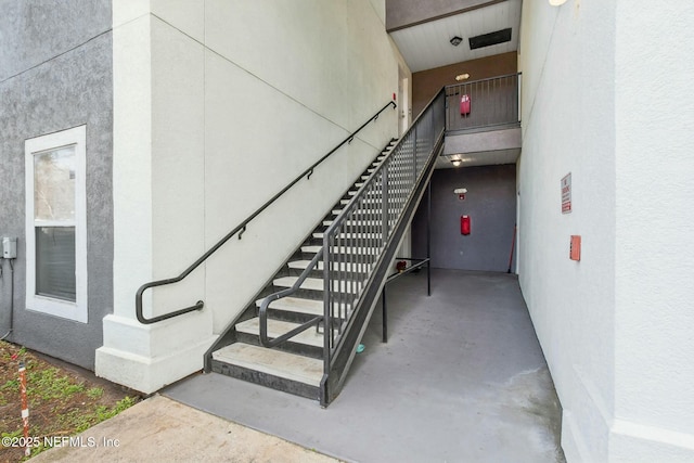 stairway featuring concrete flooring