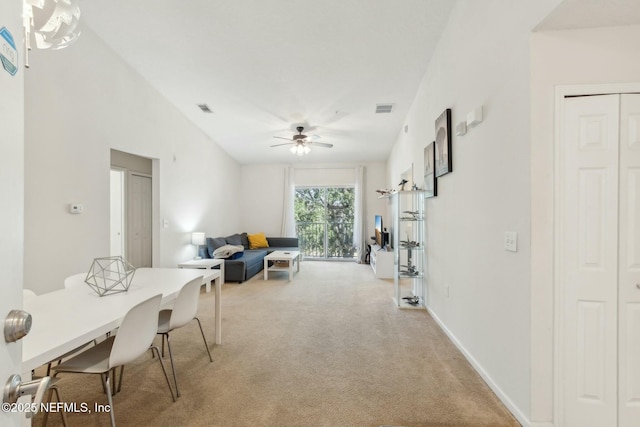 carpeted dining room with ceiling fan