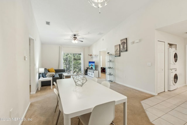 carpeted dining area featuring stacked washer / drying machine and ceiling fan