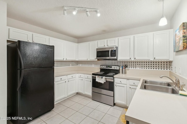 kitchen featuring light tile patterned floors, sink, appliances with stainless steel finishes, hanging light fixtures, and white cabinets