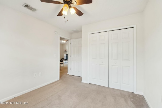 unfurnished bedroom with ceiling fan, light colored carpet, and a closet