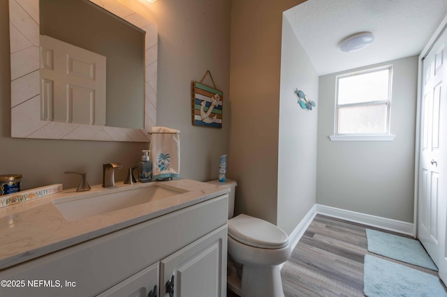 bathroom featuring hardwood / wood-style flooring, vanity, and toilet