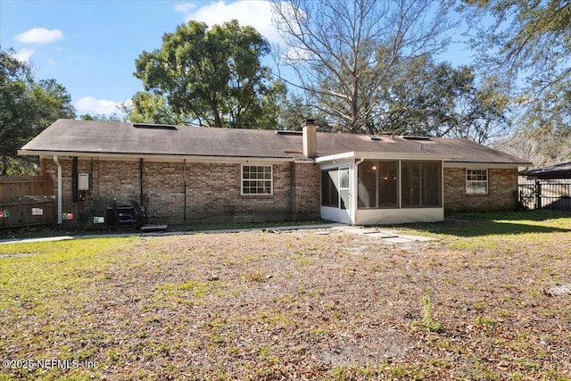 rear view of property with a sunroom and a yard