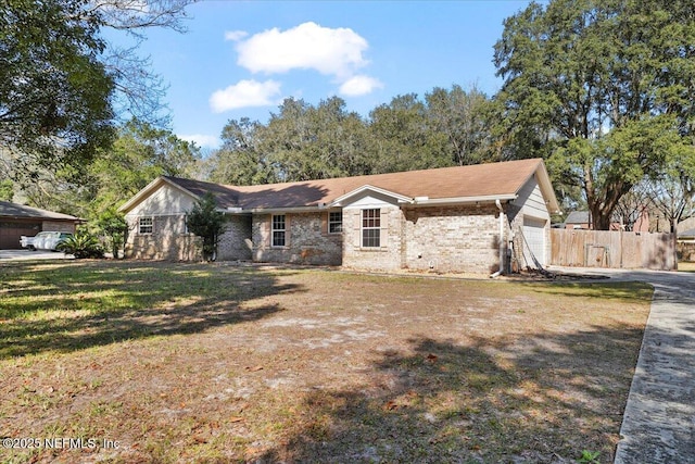 ranch-style house featuring a garage and a front lawn