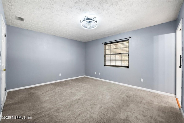 carpeted spare room featuring a textured ceiling