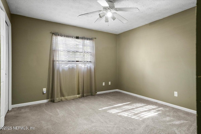 carpeted spare room featuring ceiling fan and a textured ceiling