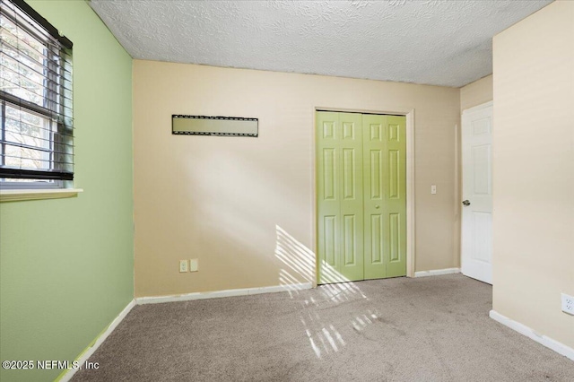 unfurnished bedroom featuring a closet, light carpet, and a textured ceiling