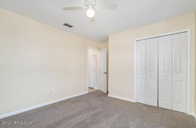 unfurnished bedroom with ceiling fan, a closet, and carpet