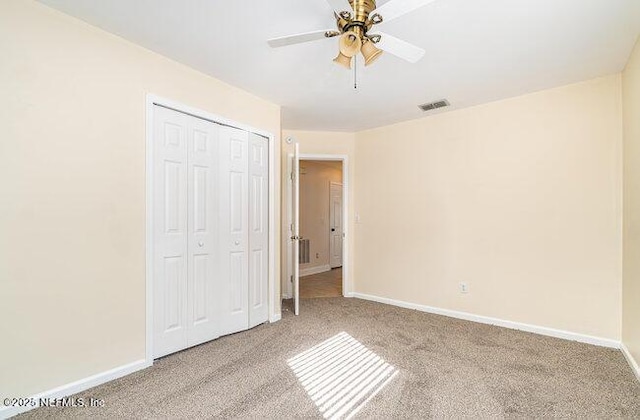 unfurnished bedroom with light colored carpet, ceiling fan, and a closet