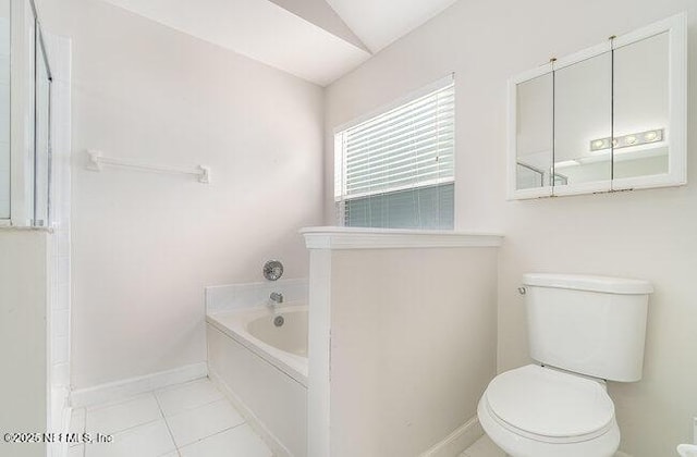 bathroom featuring tile patterned flooring, vaulted ceiling, a washtub, and toilet