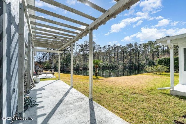 view of yard featuring a water view, a pergola, and a patio