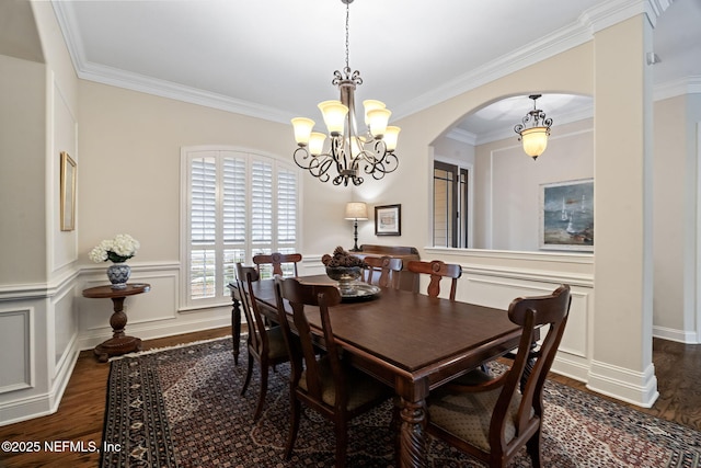 dining area featuring ornamental molding, dark hardwood / wood-style floors, and a notable chandelier