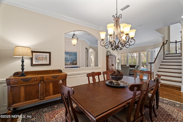 dining room featuring dark hardwood / wood-style flooring, crown molding, and an inviting chandelier