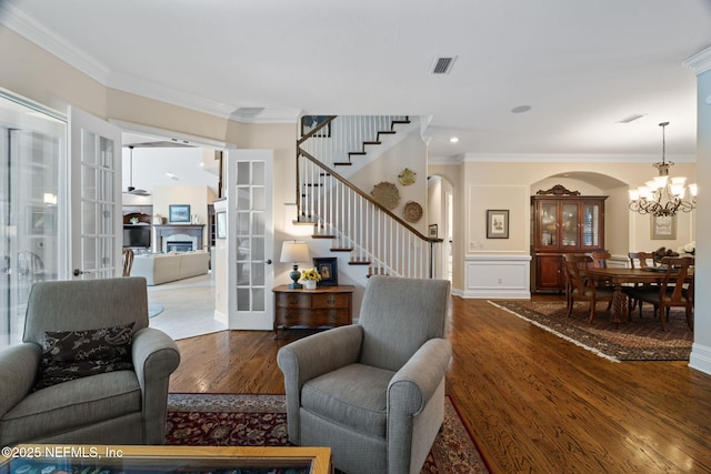 living room featuring french doors, ornamental molding, a chandelier, and hardwood / wood-style floors