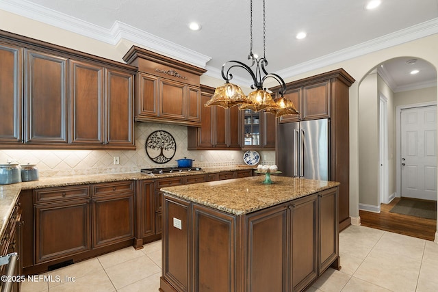 kitchen featuring hanging light fixtures, light tile patterned floors, stainless steel appliances, and a kitchen island