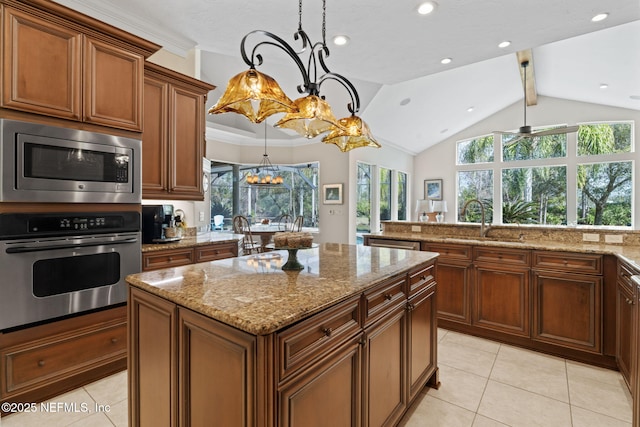 kitchen with hanging light fixtures, a kitchen island, appliances with stainless steel finishes, and sink