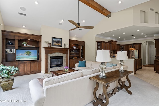 carpeted living room with ceiling fan, high vaulted ceiling, a fireplace, ornamental molding, and beamed ceiling