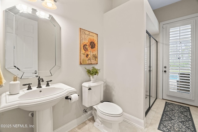 bathroom with an enclosed shower, tile patterned floors, and toilet