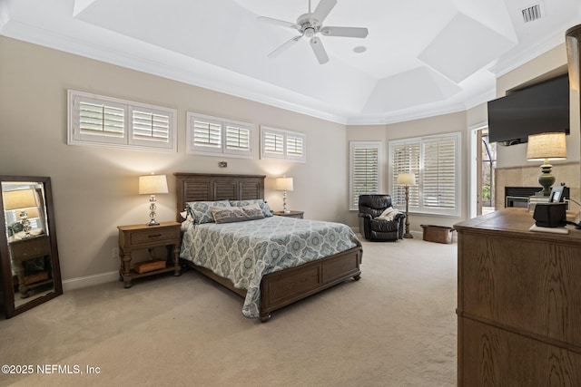 bedroom with ceiling fan, ornamental molding, a raised ceiling, and light carpet