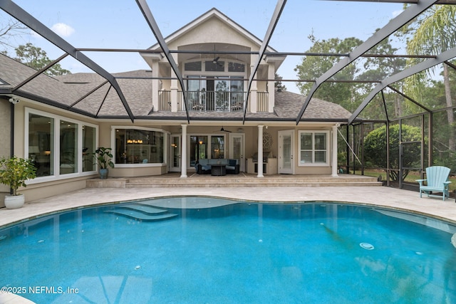 view of pool with a patio area, outdoor lounge area, ceiling fan, and glass enclosure