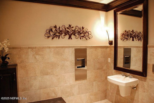 bathroom featuring sink and tile walls