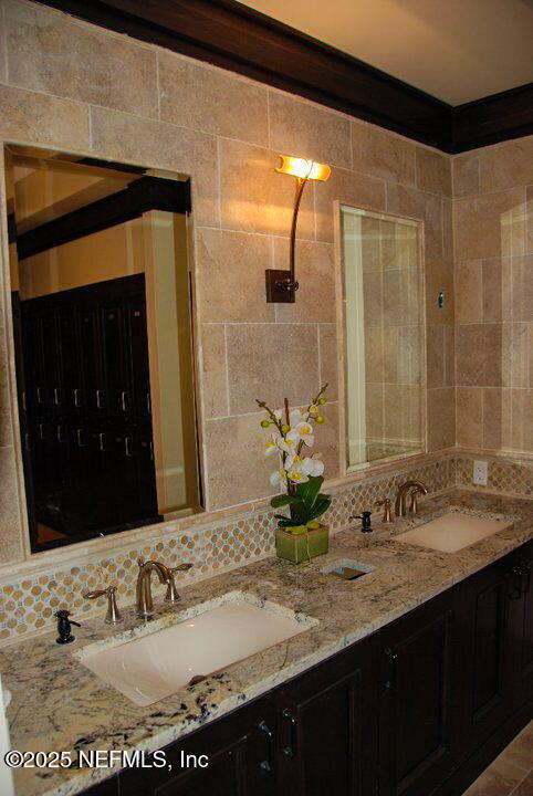 bathroom featuring tasteful backsplash, vanity, and tile walls