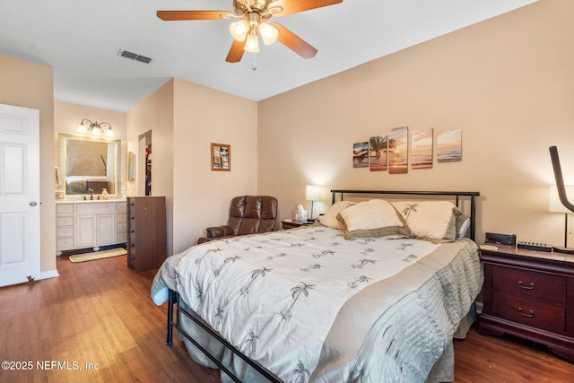 bedroom with ceiling fan, connected bathroom, and dark hardwood / wood-style flooring