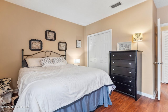 bedroom with dark hardwood / wood-style flooring and a closet