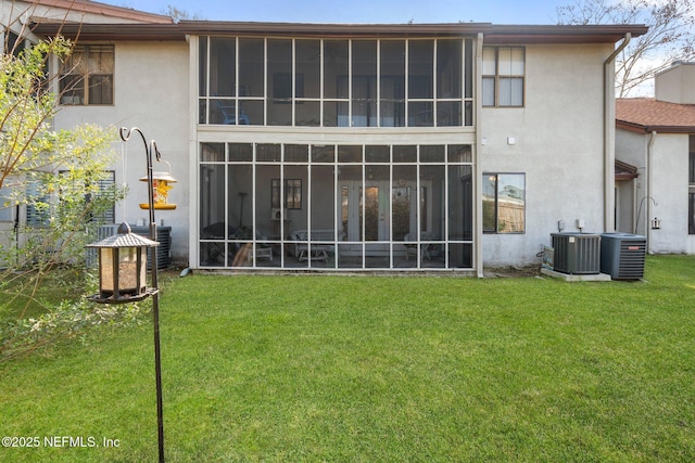 rear view of house with a lawn and central air condition unit