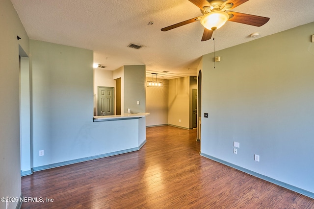 spare room with ceiling fan, dark wood-type flooring, and a textured ceiling