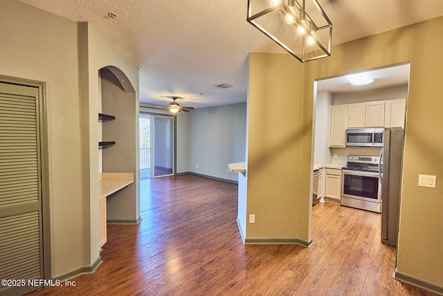 kitchen with ceiling fan, stainless steel appliances, a textured ceiling, white cabinets, and light wood-type flooring