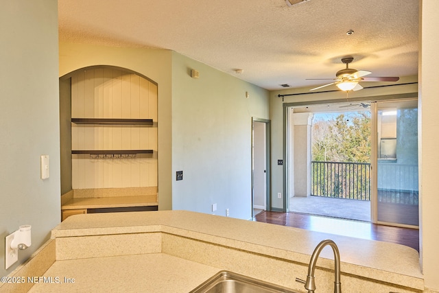 kitchen featuring sink, a textured ceiling, and ceiling fan