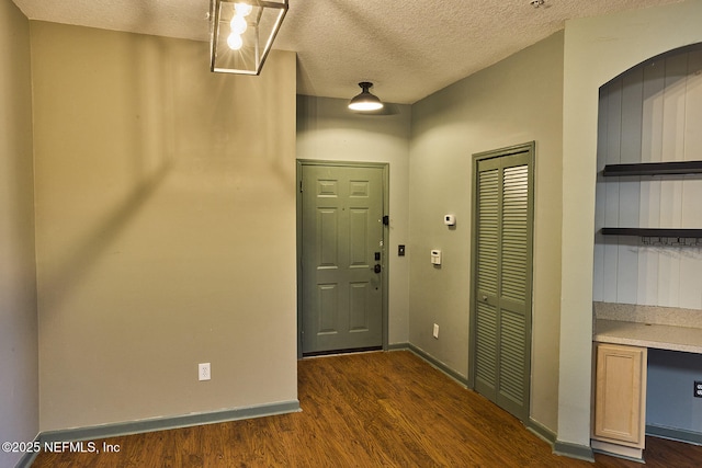 foyer with dark hardwood / wood-style flooring and a textured ceiling