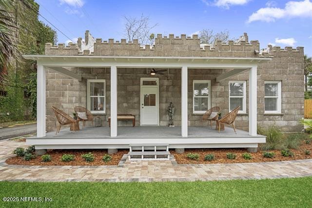 back of property with a porch and a lawn