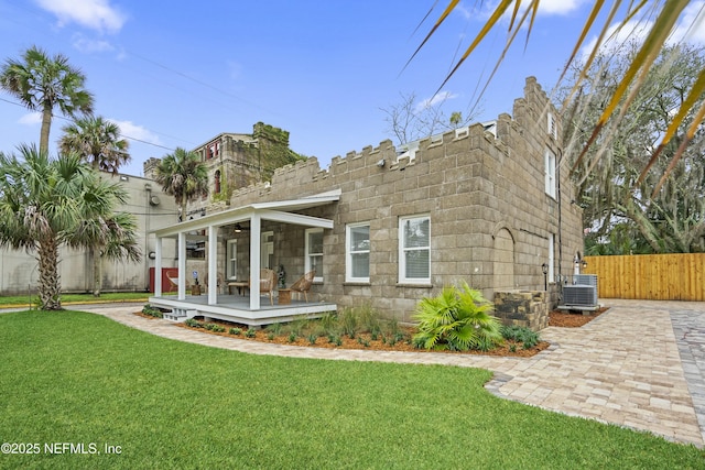 back of property featuring a yard and central AC unit