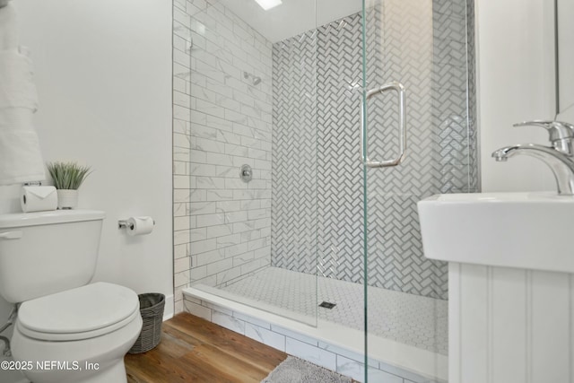 bathroom with walk in shower, sink, toilet, and hardwood / wood-style floors