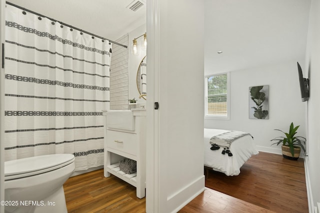 bathroom with hardwood / wood-style floors and toilet