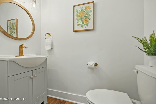 bathroom with vanity, wood-type flooring, and toilet