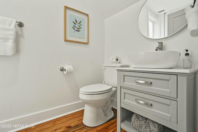 bathroom with vanity, hardwood / wood-style floors, vaulted ceiling, and toilet