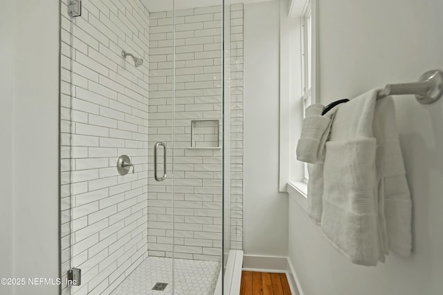 bathroom featuring a shower with door and hardwood / wood-style floors