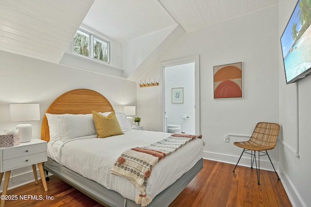 bedroom with ensuite bath, lofted ceiling, and hardwood / wood-style floors