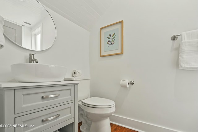 bathroom with lofted ceiling, vanity, toilet, and wood-type flooring